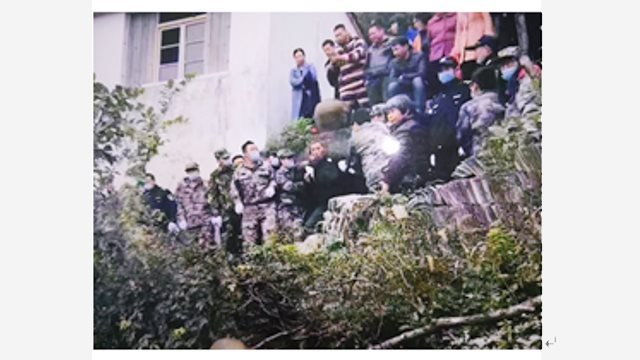 Strafvollstreckungsbeamte der KPCh ziehen ältere Dorfbewohner, die im Tempel Wache gehalten hatten, an beiden Händen den Berg hinunter.