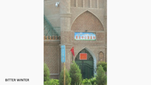  Die Halbmond- und Sternsymbole wurden von den Kuppeln der Huangtian-Zentralmoschee in Kumul entfernt. Die chinesische Flagge wurde in der Nähe des Moschee-Eingangs gehisst und links neben dem Haupteingang der Moschee wurde eine Überwachungskamera installiert, um die Gläubigen zu überwachen. Auf dem Schild am Tor steht: “Parteimitgliedern, Staatsbeamten und Minderjährigen ist der Zutritt zu religiösen Einrichtungen verboten.“