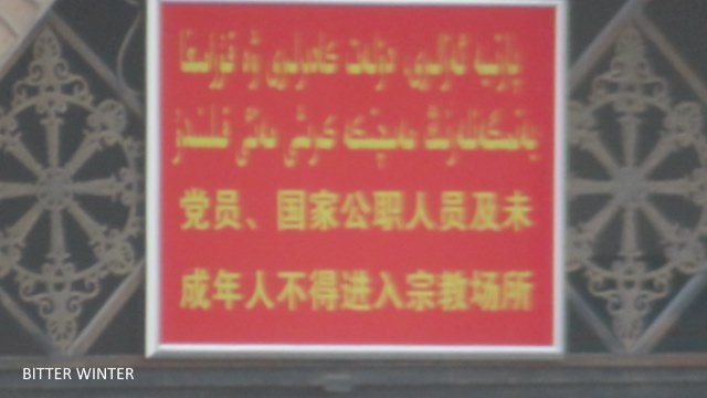  Die Halbmond- und Sternsymbole wurden von den Kuppeln der Huangtian-Zentralmoschee in Kumul entfernt. Die chinesische Flagge wurde in der Nähe des Moschee-Eingangs gehisst und links neben dem Haupteingang der Moschee wurde eine Überwachungskamera installiert, um die Gläubigen zu überwachen. Auf dem Schild am Tor steht: “Parteimitgliedern, Staatsbeamten und Minderjährigen ist der Zutritt zu religiösen Einrichtungen verboten.“