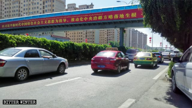 Plakat mit Propaganda-Parolen in Urumqi