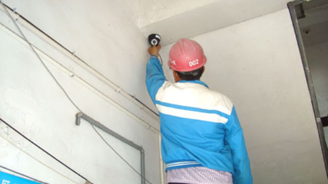 Arbeiter installiert eine Überwachungskamera.