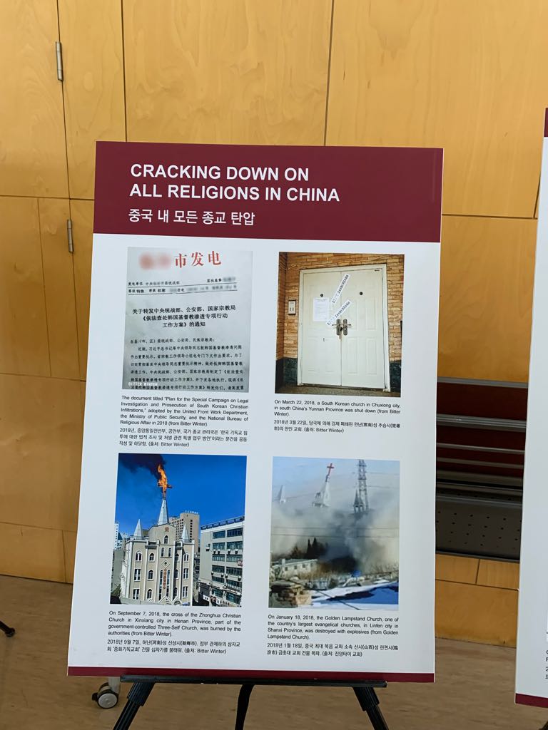 Auf Tafeln wird die Verfolgung aller Religionen in China dargestellt.