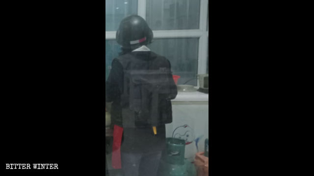 Eine Kellnerin im Café trägt bei der Arbeit eine kugelsichere Weste und einen Schutzhelm.