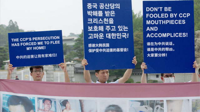 Mitglieder der KAG halten Plakate hoch und verurteilen die Gräueltaten der KPCh.