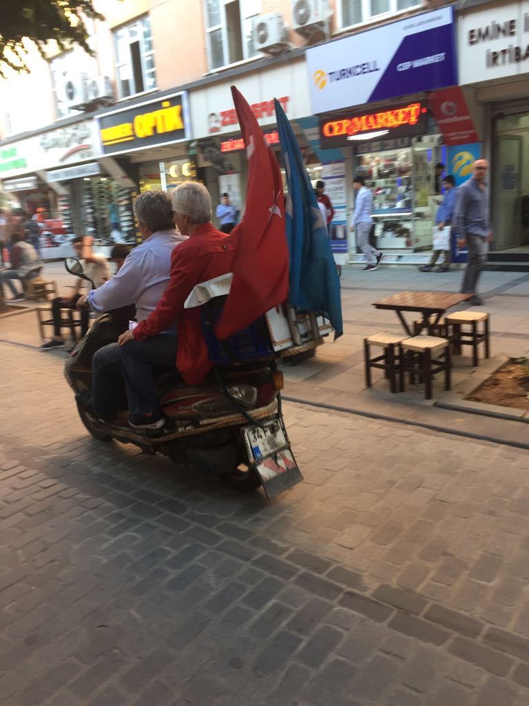 Uigurische Motorradfahrer, die sowohl die türkische als auch die turkestanische Flagge führen