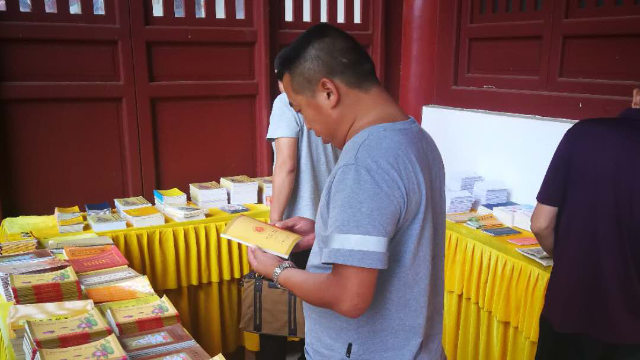 Strafvollstreckungsbeamte überprüfen buddhistische Veröffentlichungen in einem Tempel