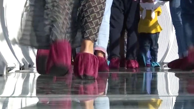 Touristen tragen Überschuhe, wenn sie die Brücke überqueren
