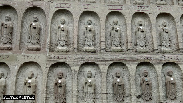 Nahaufnahme der Buddha-Statuen auf den Felswänden.