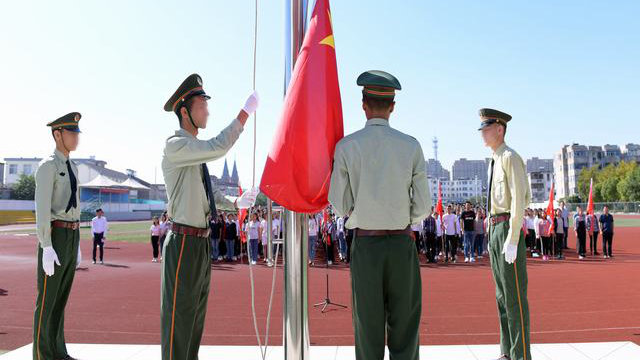 Xinjiang-Schüler in Jiangsu nehmen an einer Fahnenzeremonie teil.